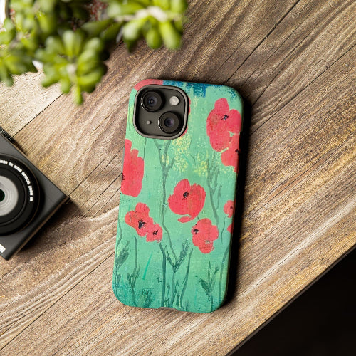 iPhone case w red poppies original artwork sitting on brown desk by Lisa Johnson Arts in Norwich Vermont